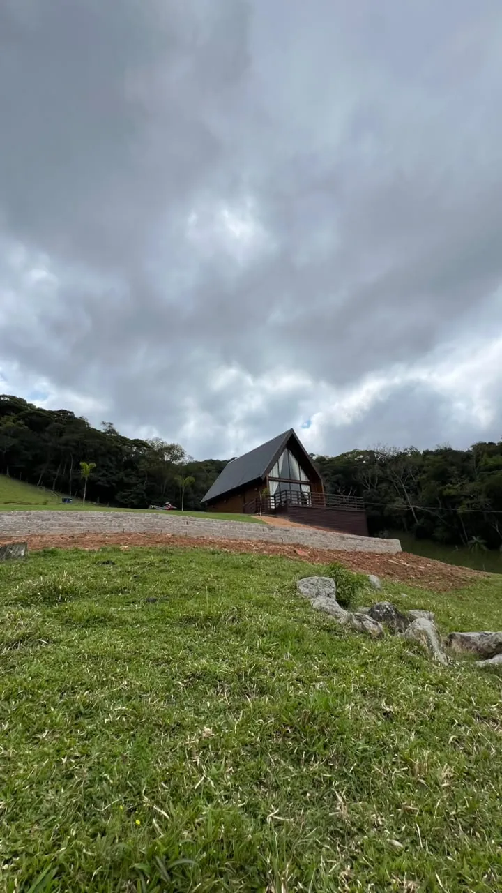 O chalé pequeno no alto da encosta sob um céu de nuvens
